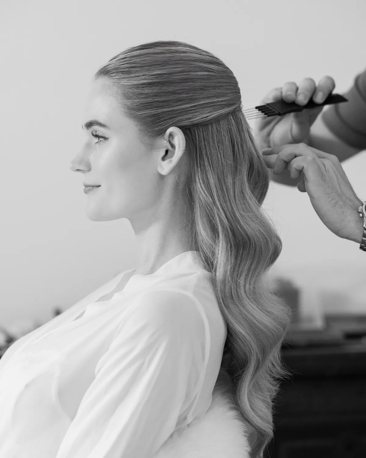 Braut im Profil, die Haare werden gestylt, schwarz-weiß